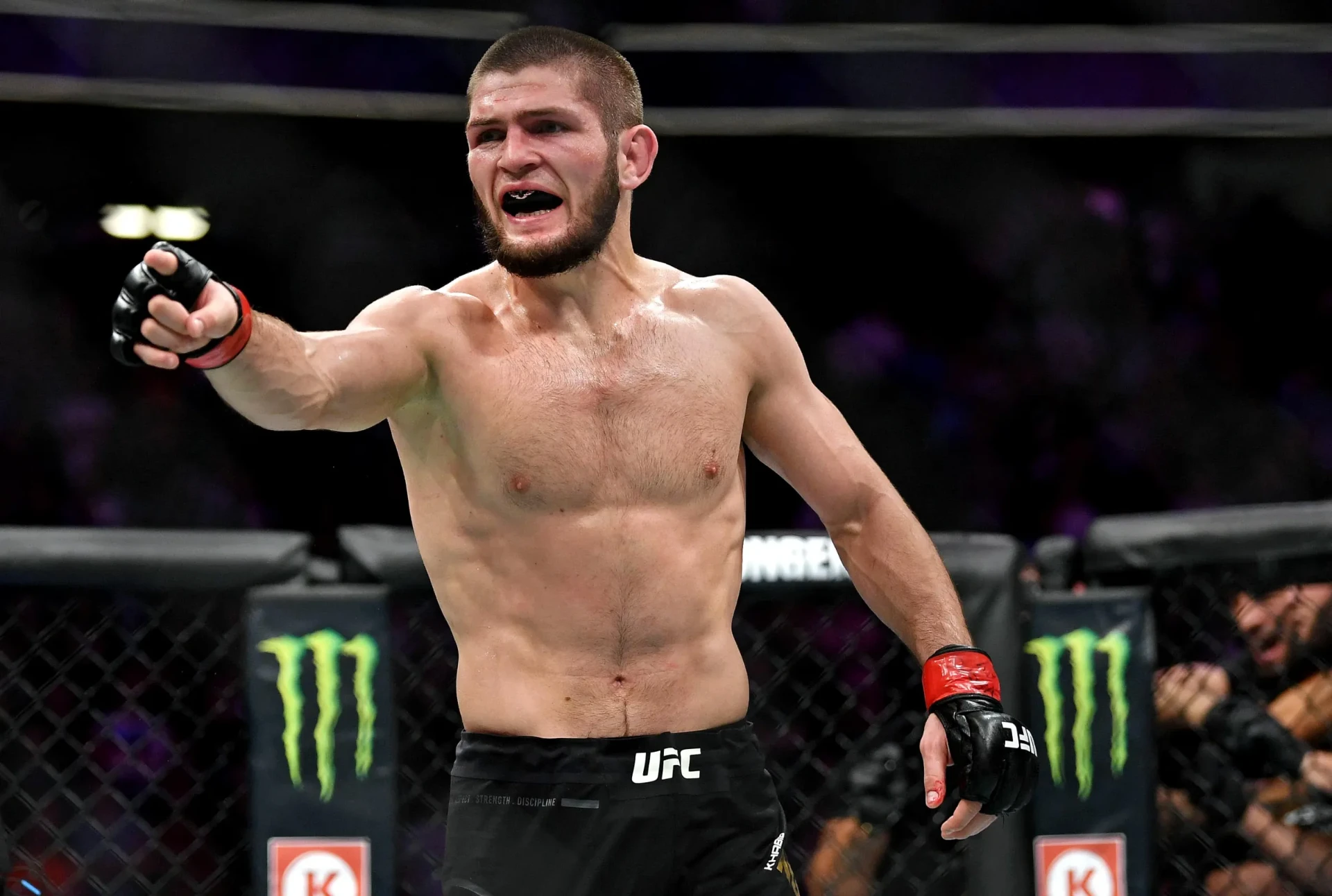 Khabib Nurmagomedov gesturing to the crowd inside the octagon after a victory