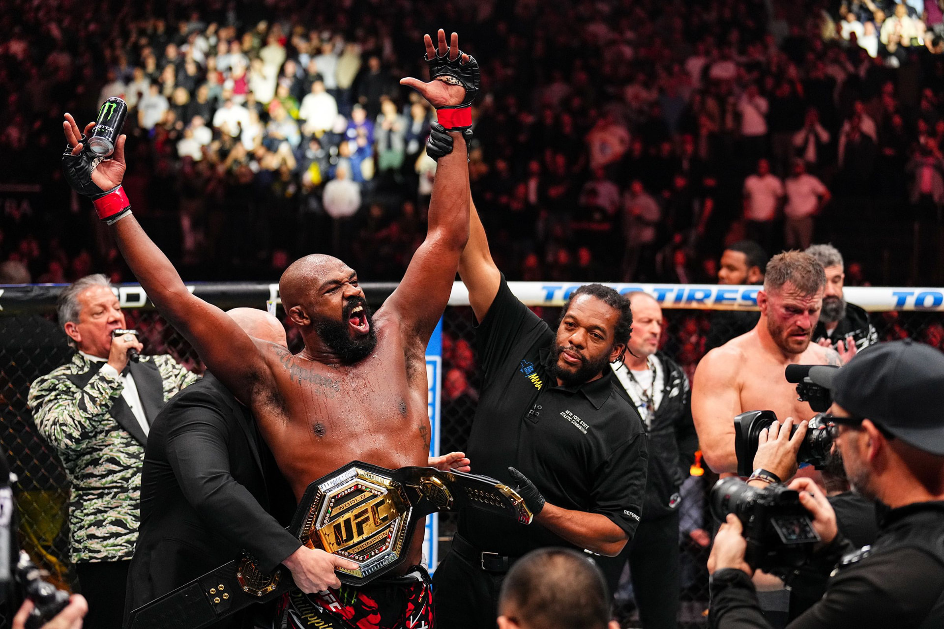 Jon Jones celebrating with his arm raised after a heavyweight title win
